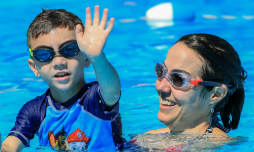 Child & Adult in swimming pool with googles